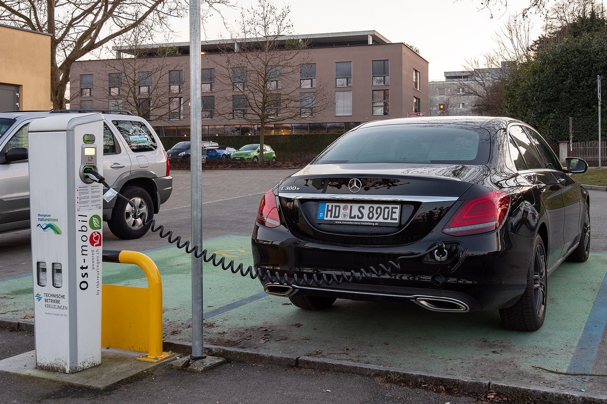 Juodas Mercedes-Benz C300e įkraunamas hibridas įkrovimo stotelėje