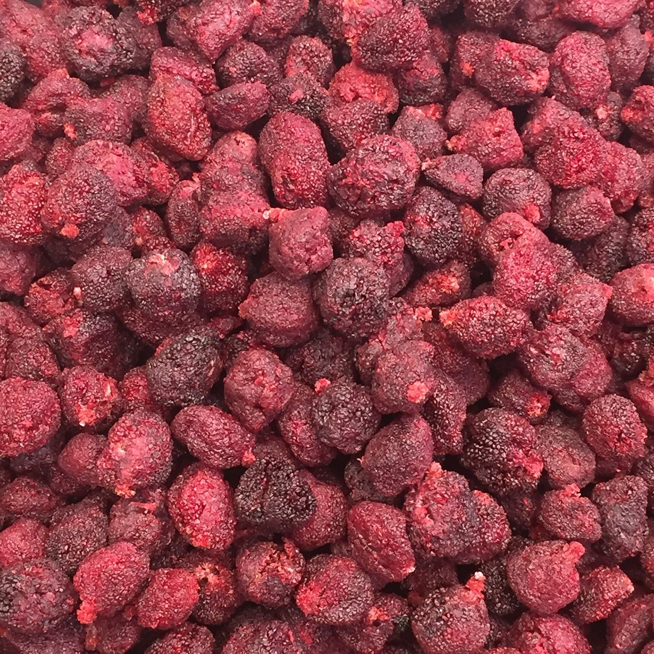 Liofilizuotų braškių gabalėliai artimu planu – sausi, porėti ir rausvi